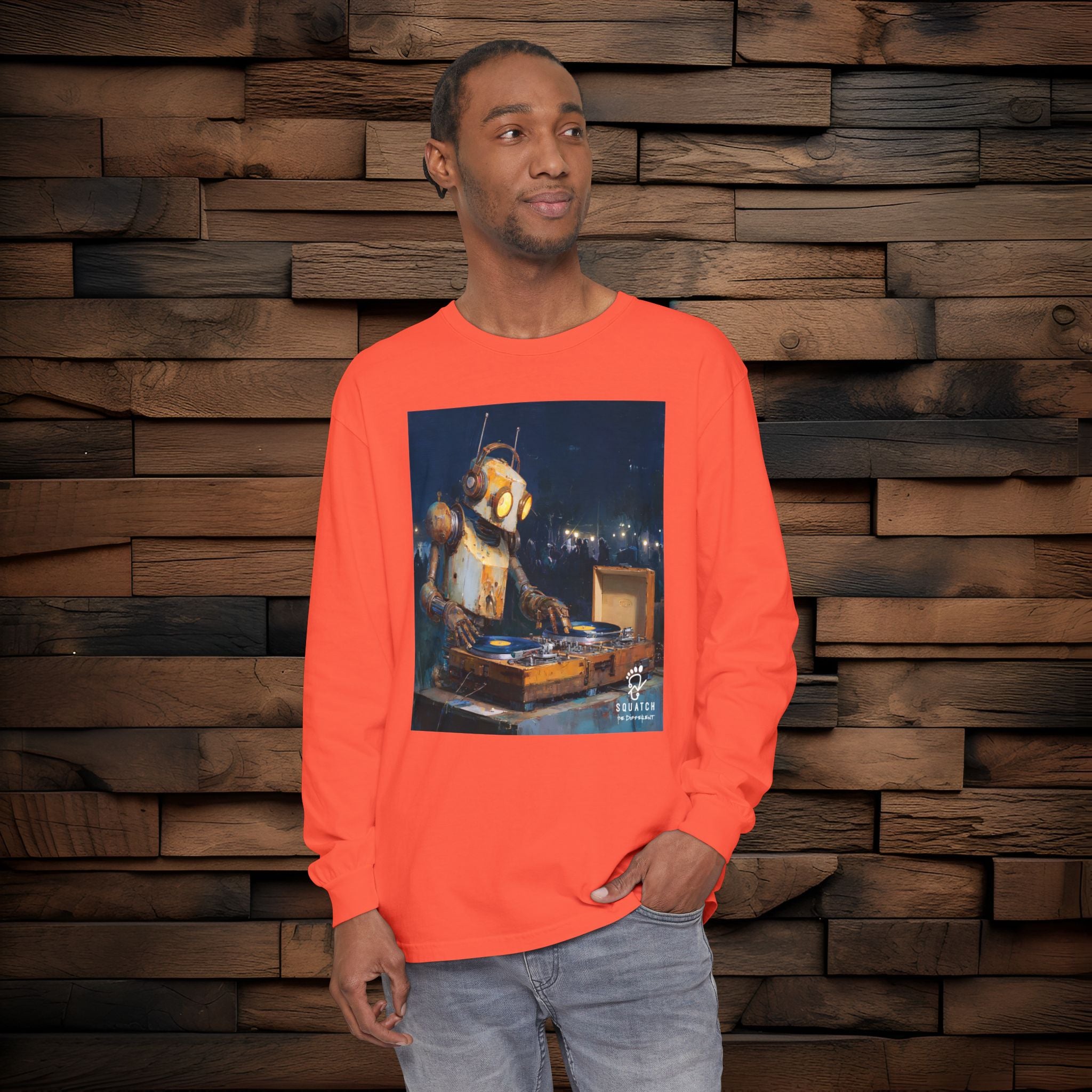 Person wearing an orange long-sleeve shirt with a graphic design against a wooden wall.