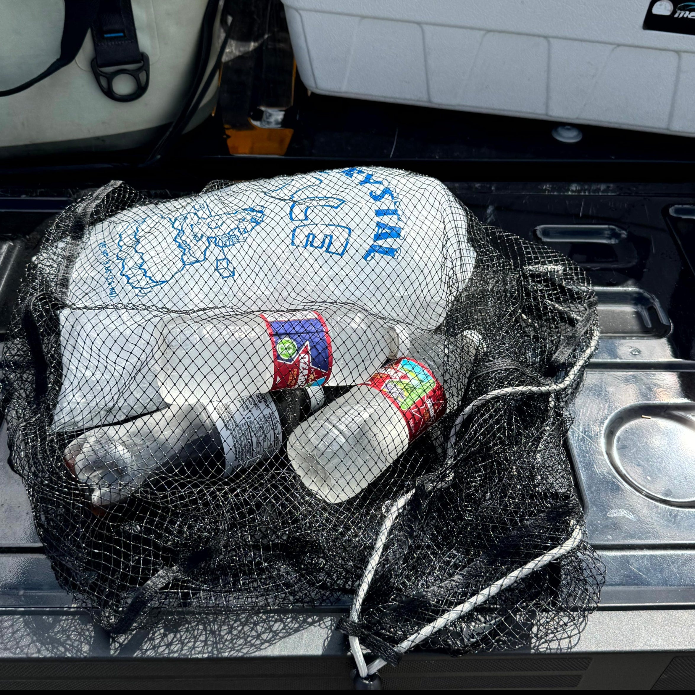 Bottles and a bag in a net attached to a vehicle's door